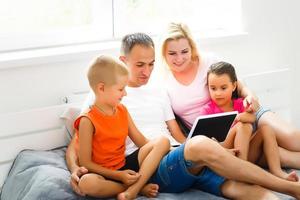 bellissimo sorridente multietica famiglia nel davanti di il il computer portatile video chiamata con lontano genitori a casa. foto