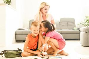 madre e bambini fare compiti a casa su il pavimento foto