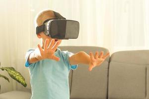 affascinato poco ragazzo utilizzando vr virtuale la realtà occhiali foto