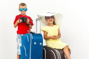 elegante famiglia di turisti trasporto valigie isolato su bianca, viaggio concetto foto