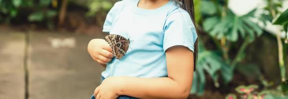 bambino con un' farfalla su il suo naso. Fata sogni per Principessa ragazza. contento infanzia concetto. foto