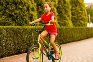 poco ragazza con sua bicicletta foto