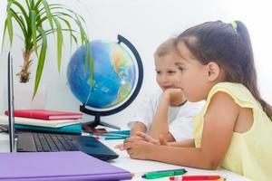 covid-19 coronavirus e apprendimento a partire dal casa, casa scuola ragazzo concetto. poco bambini studia in linea apprendimento a partire dal casa con il computer portatile. quarantena e sociale distanziamento concetto. foto