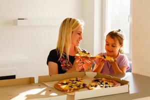 madre e figlia Pizza nel il cucina poco ragazza foto