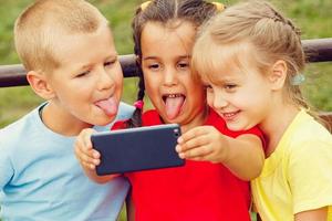 gruppo di bambini seduta su panchina nel centro commerciale assunzione autoscatto foto