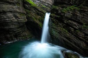 un' mistico cascata circondato di muschio foto