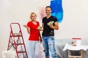 casa rifacimento e rinnovamento giovane coppia ridecorando loro nuovo Casa e pittura muri, il uomo è pendente su un' scala e in posa foto