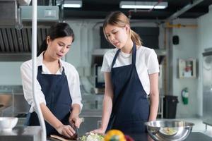 cucinando apprendisti preparare pasti e ingredienti prima il capocuoco arriva per istruire a il culinario dell'accademia cucina. foto