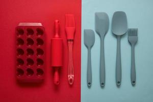 silicone culinario Accessori spatole, spazzole, forma, rotolamento perno su rosso e blu sfondo, culinario sfondo foto