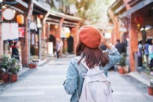 giovane donna viaggiatore a piedi nel il shopping strada, viaggio stile di vita concetto foto