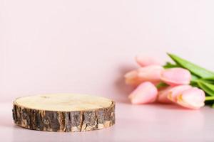 naturale modello a partire dal un' albero tagliare su un' rosa sfondo con un' mazzo di tulipani foto