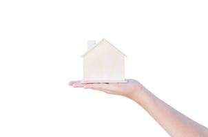 mano Tenere mostrando un' piccolo di legno Casa isolato su bianca sfondo. concetto di casa prestito e acquisto un' Casa, assicurazione. foto