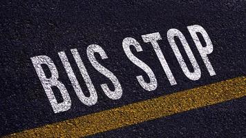 autobus fermare testo scritto e giallo linea su il strada nel mezzo di il asfalto strada, autobus fermare parola su strada. foto