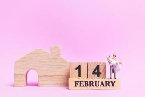 matrimonio in miniatura di una coppia di sposi su uno sfondo rosa, concetto di San Valentino foto