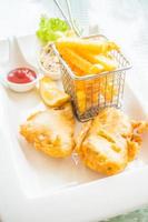 pesce e patatine fritte su un piatto bianco foto