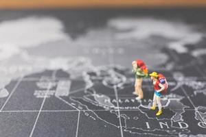 backpackers in miniatura che camminano su una mappa del mondo, turismo e concetto di viaggio