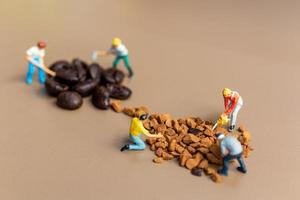 squadre in miniatura che lavorano insieme sulla miscelazione del caffè foto