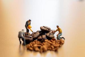 squadre in miniatura che lavorano insieme sulla miscelazione del caffè foto