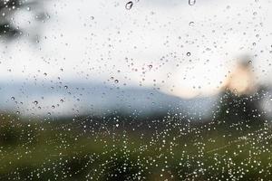 gocce di pioggia su una superficie di vetro di una finestra foto