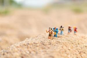 viaggiatori in miniatura con zaini che camminano sulla sabbia, viaggi e concetto di avventura