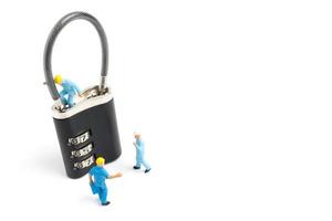 lavoratori in miniatura che sbloccano la password su un lucchetto, concetto di lavoro di squadra foto