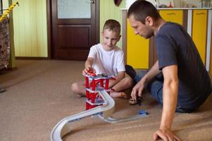 allegro papà giochi con un' carino ragazzo a casa nel macchine foto