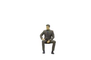 uomo d'affari in miniatura seduta isolato su uno sfondo bianco foto