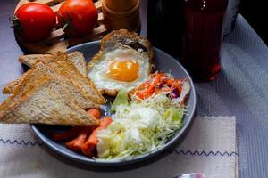 colazione, fritte uova, fritte salsiccia, verdura insalata e crostini su un' Marrone di legno tavolo con caffè. foto