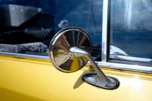 cromato posteriore Visualizza specchio di un vecchio giallo auto a partire dal il anni sessanta foto