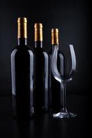 bottiglie di vino e vetro con sfondo nero foto