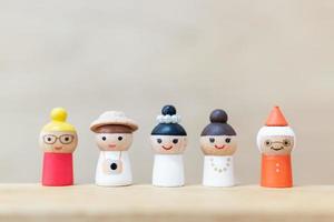 bambole di legno in miniatura con facce felici su uno sfondo di legno foto