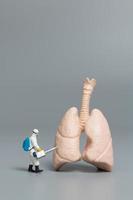 medico in miniatura che osserva e discute il concetto di polmone umano, virus e batteri foto
