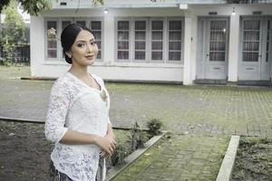 un' giovane indonesiano donna con un' contento riuscito espressione indossare un' bianca kebaya. di Kartini giorno concetto. foto