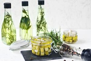 feta marinata in un barattolo di vetro, spezie e olio d'oliva aromatizzato su uno sfondo di legno