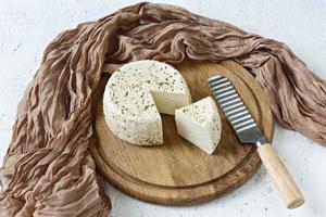 formaggio bianco su una tavola di legno su uno sfondo bianco foto