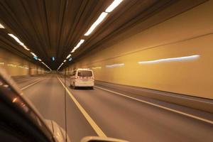 un' speciale auto si precipita a alto velocità nel un' illuminato tunnel, più blu, defocus foto