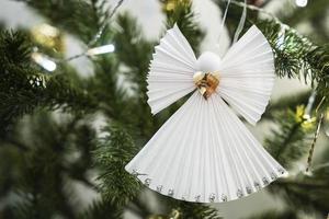 un' figurina di un' Natale bianca angelo su un' ramo di un' Natale albero foto