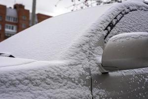un' innevato macchina, un' auto nel il soffice primo neve, il inizio di inverno, mattina preoccupazioni foto