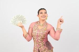 giovane bellissimo donna vestito su nel Locale cultura nel meridionale regione posa con banconota foto