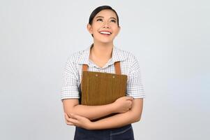 ritratto di giovane asiatico donna nel cameriera uniforme posa con appunti foto