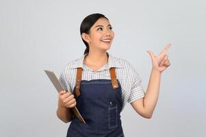 ritratto di giovane asiatico donna nel cameriera uniforme posa con appunti foto