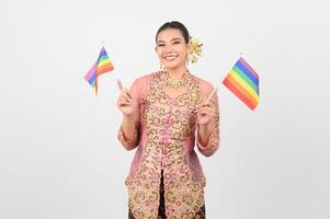 giovane bellissimo donna vestito su nel Locale cultura nel meridionale regione con arcobaleno bandiera foto