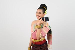 giovane bellissimo donna vestito su nel tailandese settentrionale regione posa con smartphone foto