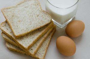 affettato totale Grano pane, bollito uovo e latte per prima colazione foto