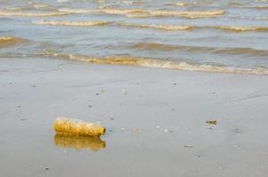 plastica bottiglia rifiuto su spiaggia per inquinamento concetto foto