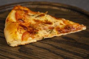 un' pezzo di delizioso Pizza su un' di legno quercia tavola. superiore Visualizza di un' delizioso appena al forno caldo Pizza foto