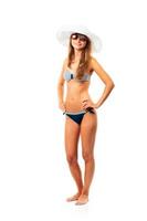 ritratto di un' bellissimo giovane donna in posa nel bikini, cappello e occhiali da sole su bianca foto