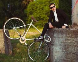 giovane elegante tipo con bicicletta all'aperto foto