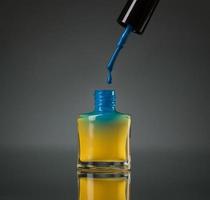 fluente blu chiodo polacco nel il giallo bottiglia isolato foto