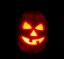 Halloween zucca jack-o-lanterna candela illuminato, isolato su nero foto